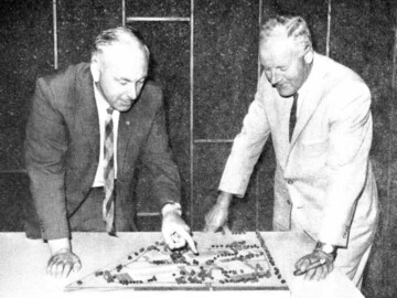 J. Wadell building engineer, (L), and R.F. Errington, V.-P. Commercial Products, (R) study a mock-up of the new site in South March, Ottawa in mid-1967. The main production shops were occupied in late 1965 and the office complex was completed in 1968. The new complex, located on the very western edge of Ottawa, simplified the route and shortened the distance and time needed to get short-lived isotopes from CRNL to Commercial Products for delivery to customers.
<br /><br />
Photo source and caption – AECL Review, August 1967. 105-1000