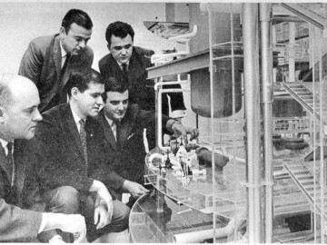 Hydro-Quebec engineers attached to the CANDU-BLW division study an engineering model of the reactor system.<br /><br />Photo and caption source- AECL Review, March 1967. 112-1000