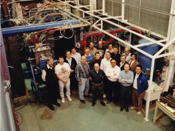 Contributors to the RFQI program. Photo taken 5 April 1993 just before dismantling and transfer of the accelerator to Los Alamos National Laboratory. L-R: T. Taylor, N. Griffith, W. Michel, G. Morin, R. Kelly, R. Bakewell, J. Mouris, J. Weaver, A. Davidson, R. Samson, G. McMichael, S. Craig, J. Sheikh, B. Smith, D. Proulx, L. Shankland, K. McKee, J. Ungrin and T. Picard. The subsequent performance of the accelerator at Los Alamos was reported by G.O. Bolme et al. See link (AA10). Although all accelerator research on high-current proton accelerators ceased in 1993 at AECL, interest and research has continued worldwide. B.P. Bromley of CRNL published an overview of the topic in 2013. See link (AA11).<br /><br />Photo source-AECL. 115-1000