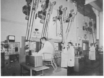 Cobalt-60 being loaded into containers in Commercial Products hot cells.
<br /><br />
Photo and caption source – AECL Review, May 1964. 118-1000-1