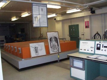 The facility was decommissioned in 2016 and the control desk, shown on the left of the figure, has been donated to the Society.
<br /><br />
Photo source – AECL. 129-1000