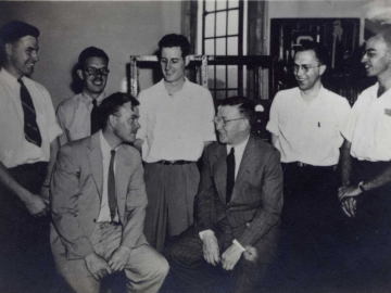 L-R: R.C. Hawkins, A.L. Harkness, H. Thode, H. Duckworth, J. Cockcroft, R.L. Graham, D.T. Roberts (?) or R.S. Smith(?). <br/>(Photo source - Diana McElroy (daughter of R.L. Graham)) Cockcroft visits Thode’s Group at McMaster, July, 1945